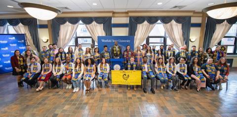 Students sit and pose with new Sankofa stoles.