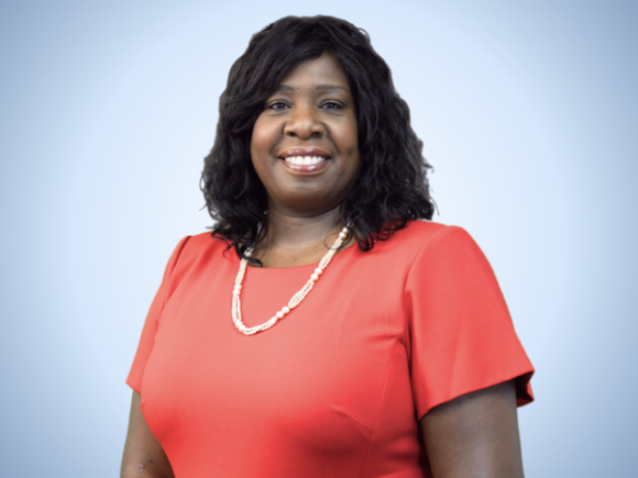 Dr. Sonia Dinnall ’88, alumna of the University, is now the first woman in Springfield Public Education history to be appointed to superintendent. She is wearing a peach colored shirt and posing in front of a light blue background.