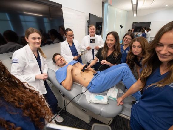 Students and Assistant Professor Chelsea Robitaille of the Physician Assistant Program using the program's new ultrasound technology during a class workshop.