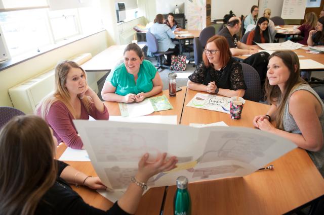 Photo of an education class visit with instructor and students talking in a circle