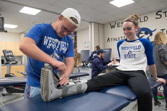 Sports medicine program students at Westfield State University practice putting on a foot and ankle brace in rehabilitation facility.