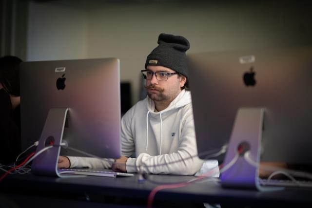 Student working on a MAC computer in a graphic design class.