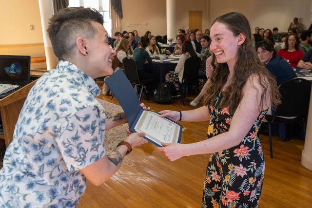 A Westfield State University student smiles as they are handed a certificate at the annual English Spring Gathering.